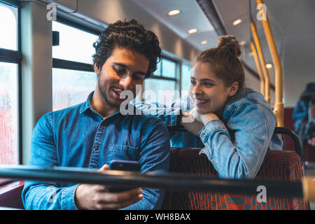 Coppia giovane viaggiando in autobus sul giorno di pioggia, London, Regno Unito Foto Stock