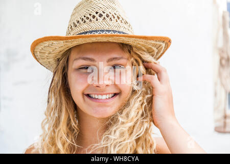 Ritratto di sorridere donna bionda che indossa cappello di paglia Foto Stock