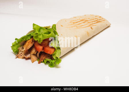 Shawarma isolato con un'ombra. Oriental cibo fatto da carne di pollo, pomodori e cetrioli in pane pita. Foto Stock
