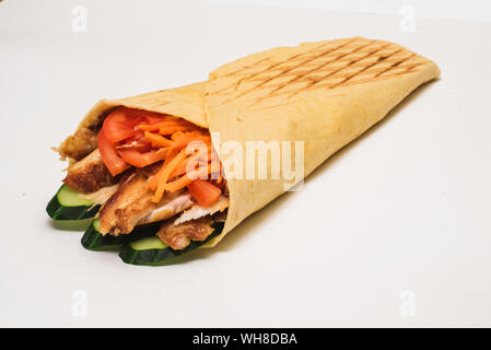 Shawarma isolato con un'ombra. Oriental cibo fatto da carne di pollo, pomodori e cetrioli in pane pita. Foto Stock