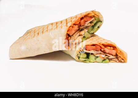 Shawarma isolato con un'ombra. Oriental cibo fatto da carne di pollo, pomodori e cetrioli in pane pita. Foto Stock