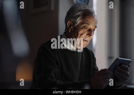 Senior uomo utilizzando tablet a casa Foto Stock