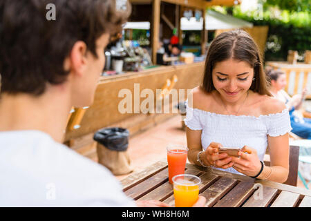 Coppia giovane in un cafe, donna utilizza lo smartphone Foto Stock