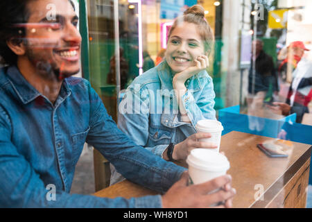 Ritratto di sorridente giovane donna in una caffetteria guardando il giovane uomo Foto Stock