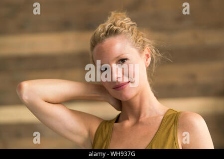 Ritratto di bella donna bionda, sullo sfondo di legno Foto Stock