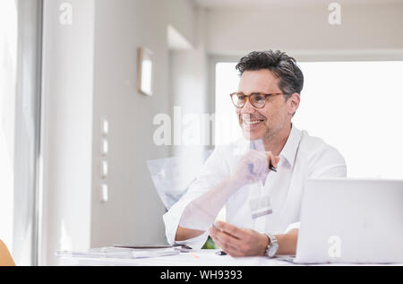 Arcitect preparare la presentazione, seduta in ufficio guardando il foglio piano Foto Stock