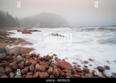 Una lunga esposizione delle onde che si infrangono sulla colorata rocce rosa Black Brook Cove Beach, Cape Breton, Nova Scotia, Canada, America del Nord Foto Stock