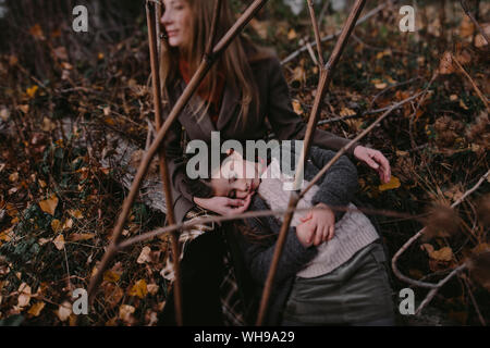 Ritratto di bambina con la testa nella sua madre giro in natura autumnul Foto Stock