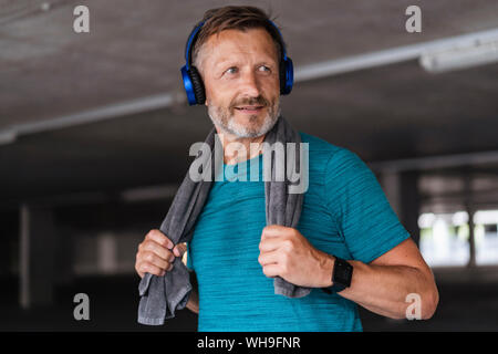 Uomo sportivo che indossano le cuffie dopo allenamento Foto Stock