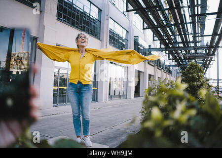 Ritratto di sorridere donna matura con le braccia aperte Foto Stock