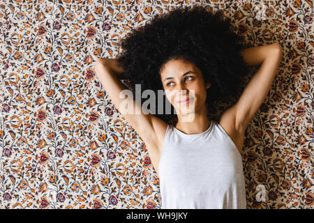 Ritratto di un felice giovane donna sdraiata su un tappeto Foto Stock