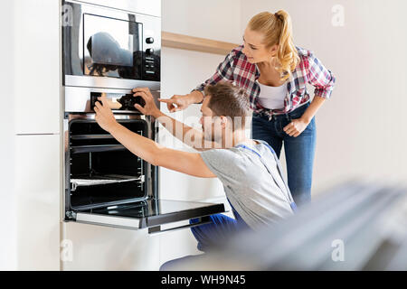 Artigiano l'installazione di un nuovo forno in cucina Foto Stock