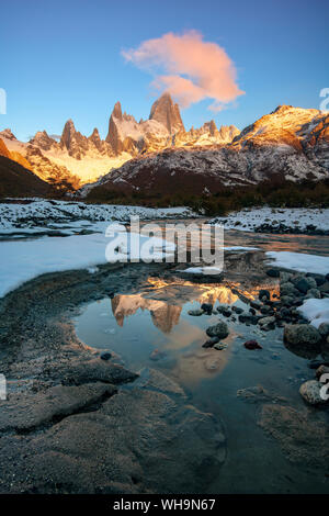 Il monte Fitz Roy a sunrise riflessa nel fiume che scorre, parco nazionale Los Glaciares, UNESCO, El Chalten, Santa Cruz Provincia, Patagonia, Argentina Foto Stock