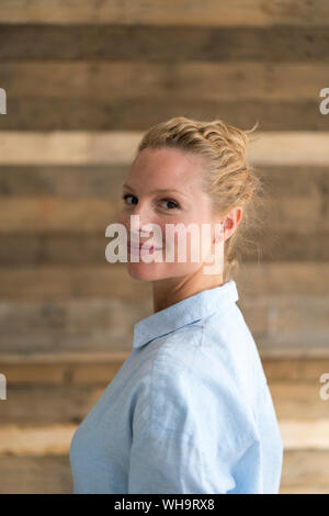 Ritratto di bella donna bionda, sullo sfondo di legno Foto Stock