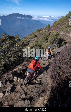 Mountain bikes passato velocità in una sfocatura lungo una Enduro style single track trail in Nepal Himalaya vicino alla regione di Langtang, Nepal, Asia Foto Stock