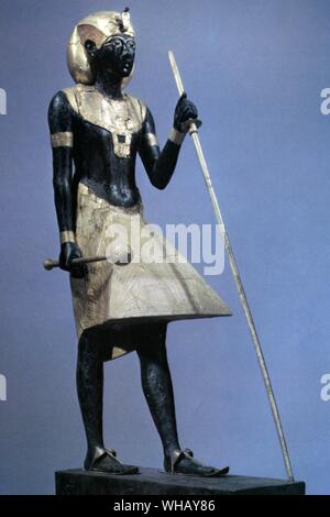 Uno dei due la vita statue a grandezza naturale del re di legno nero con applicato il gesso dorato. Tukankhamen, da Christiane Desroches Noblecourt, pagina 1.. Due statue sono state scoperte nell'anticamera della tomba reale, affacciati su entrambi i lati dell'ingresso sigillato alla camera di sepoltura. Le statue di raffinata artigianalità sono sorprendenti in entrambi la loro vita-dimensioni e la finitura nera della pelle, rivelando la specialità dell'artista che ha saputo investire le loro caratteristiche con un senso di quasi il potere soprannaturale essi brandita come custodi della camera di sepoltura. La pelle nera Foto Stock