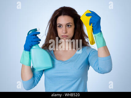 Giovani belle sconvolto casalinga donna tenendo la benna mop spray per la pulizia di sensazione ha sottolineato stanco e deluso in compiti domestici e i ruoli di genere conc Foto Stock