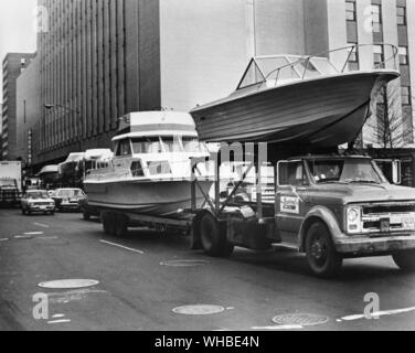 63National Boat Show - New York City residenti trattati alla vista di-46-piede di incrociatori e imbarcazioni sportive piggybacked su rimorchi buge rendendo il loro modo attraverso il West 58th Street al Colosseo di New York, sito del National Boat Show che questo anno corre da gennaio 26 attraverso il 4 Febbraio e ospita centinaia di barche e barca-Mostra correlati. Le barche sul display venuti da lontano come stato di Washington - e, per la prima volta nei suoi 63 anni di storia la mostra ospiterà un gruppo di 19 aziende provenienti da Australia. - 1° dicembre 1973. Foto Stock