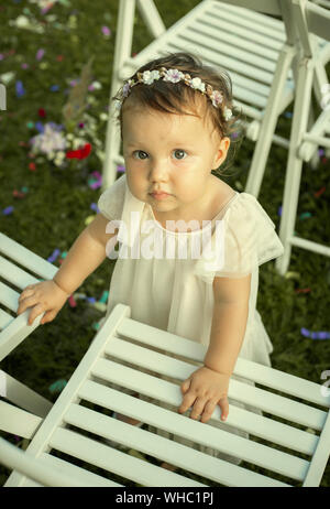 Carino Baby girl in abito bianco su un matrimonio di famiglia Foto Stock