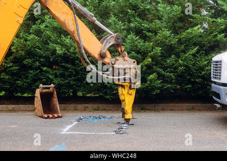 Asfalto demolendo con opere di costruzione di grandi dimensioni strumento jackhammer frantumazione di asfaltatura durante la guida su strada Foto Stock