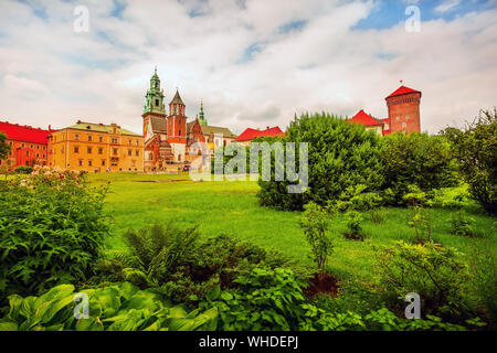 Cracovia in Polonia, il Castello Reale di Wawel colorato vista da cartolina contro di fiori e alberi verdi in giardino Foto Stock