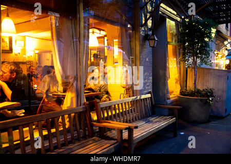 NEW YORK CITY - Agosto 24, 2019: Street scene con ristorante, le luci e le persone a notte visto da Greenwich Village, West Village di Manhattan. Foto Stock