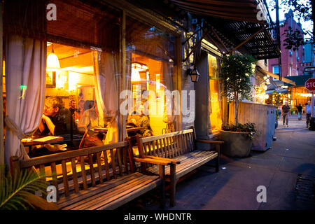 NEW YORK CITY - Agosto 24, 2019: Street scene con ristorante, le luci e le persone a notte visto da Greenwich Village, West Village di Manhattan. Foto Stock