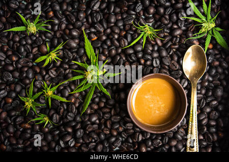 Tazze di caffè con la marijuana e fagioli arrosto su un tavolo Foto Stock