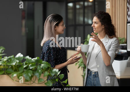 Due giovani di business diversi donne parlare durante la pausa di lavoro Foto Stock