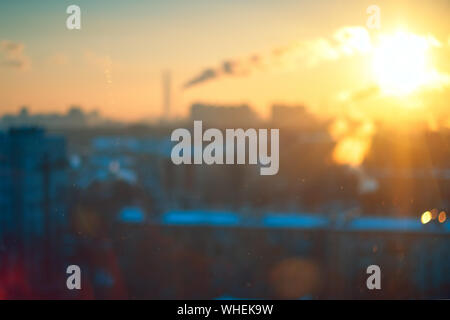 Incredibile vintage blu ambra luce del tramonto con sfocate paesaggio urbano industriale skyline sfondo bokeh congelate attraverso il vetro di una finestra. Soft focus. Foto Stock
