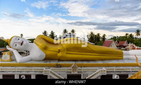 Bella bianca e oro statue del Buddha in posizione reclinata sotto il cielo blu di sera al Wat che noi, è tempio Buddista sono landmar Foto Stock