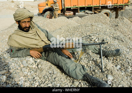 Un membro dell'esercito nazionale afghano (ANA) prendendo una posa rilassata durante le operazioni di sicurezza nella provincia di Helmand, Afghanistan meridionale Foto Stock