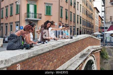 LIVORNO, Italia - Luglio 11, 2019: persone fare schizzi sul ponte con il quartiere Venezia Nuova. Livorno è una città sul mare ligure con uno dei th Foto Stock