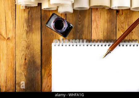 Vecchio stile di calligrafia pennino, inchiostro e carta vergine su un tavolo di legno. Accessori per scrittura preparato per lavoro. Sfondo scuro. Foto Stock