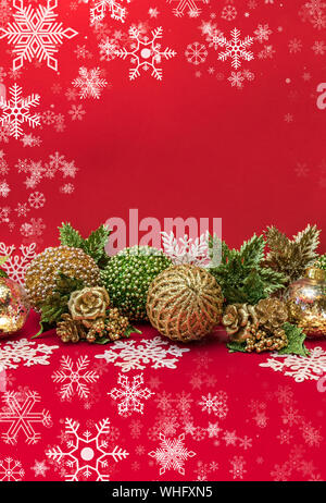 Golden, bianco e verde di Natale decorazione su sfondo rosso Foto Stock