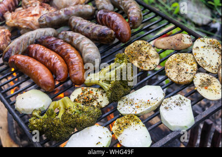 Salsicce fritte con verdure alla griglia. Cibo sano. Cibo alla griglia, mangiare sulla griglia dal fuoco Foto Stock