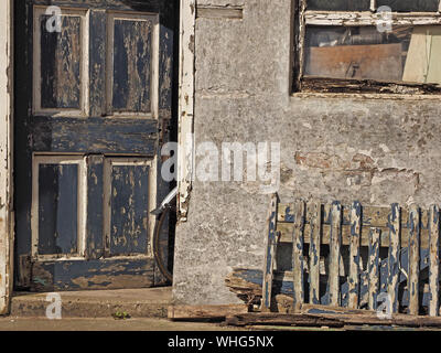 Una ruota posteriore di bicicletta & parafango sporgono dalla porta di un distressed dipendenza con rivestimenti di legno fatiscenti a Anstruther, East Neuk,Fife, Scozia, Regno Unito Foto Stock