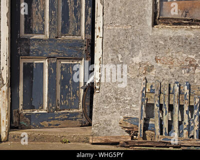 Una ruota posteriore di bicicletta & parafango sporgono dalla porta di un distressed dipendenza con rivestimenti di legno fatiscenti a Anstruther, East Neuk,Fife, Scozia, Regno Unito Foto Stock