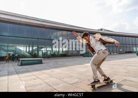 Ragazzo Afro giostre e facendo ruotare sul suo skateboard Foto Stock