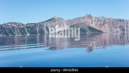 Una vista del cratere del lago e Wizard Island in Oregon. Il lago è famoso per il suo profondo blu il colore e la limpidezza dell'acqua. L'isola vulcanica di un cono di scorie. Foto Stock