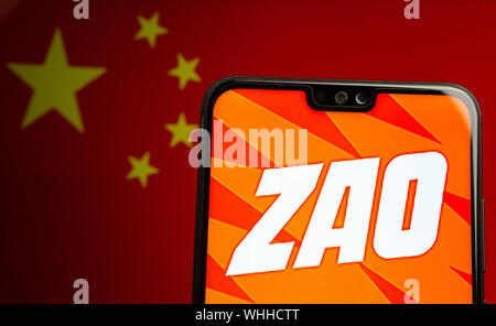 ZAO app logo sullo schermo dello smartphone e la bandiera sfocata della Cina sullo schermo dietro. Zao è attualmente un numero una divertente app in Cina. Foto Stock