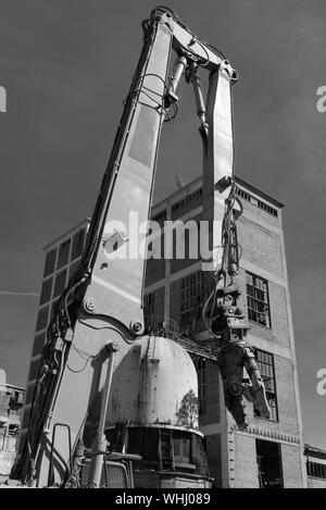 Pinze di demolizione su un escavatore in un cantiere in bianco e nero Foto Stock