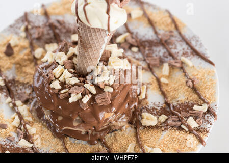 Deliziose frittelle di banane e latte gelato, pezzi di bianco e marrone cioccolato ,sciroppo dolce, trucioli di noce di cocco e un sacco di glassa di cioccolato. Vista superiore vicino. Foto Stock