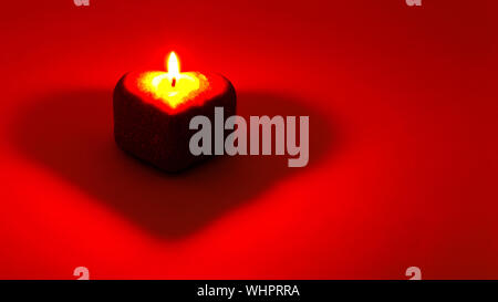 Cuore su sfondo rosso. Una candela accesa a forma di cuore. Vuoto per cartoline. Biglietto di auguri su buon giorno della donna, la giornata internazionale della donna Foto Stock