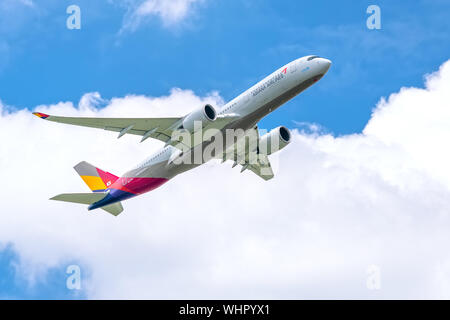 Aereo passeggeri Airbus A350 di Asiana Airlines Volare attraverso le nuvole del cielo il decollo dall'Aeroporto Internazionale Tan Son Nhat di Ho Chi Minh City, Vietna Foto Stock