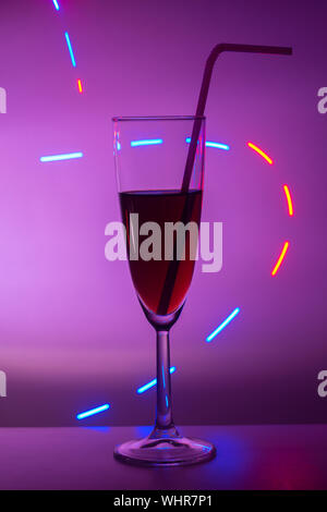Bicchieri di champagne. Vetro o stemware con alcool o un cocktail su uno sfondo colorato. Un bicchiere sulla barra in un bar, ristorante, discoteca o di Foto Stock