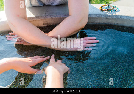 Acque curative. Proprietà di salute dell'acqua. Mano in acqua. Foto Stock