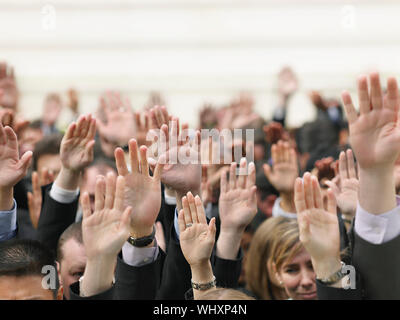 Primo piano della folla di business alzando le mani Foto Stock