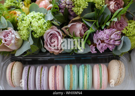 Amaretti nella casella di color turchese con fiori freschi. Eleganti colori in polvere. Alla vigilia del giorno della madre e la Giornata della donna Foto Stock