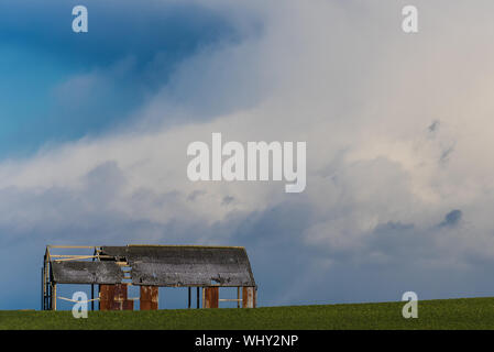 Fienile abbandonati contro il cielo in tempesta. Foto Stock